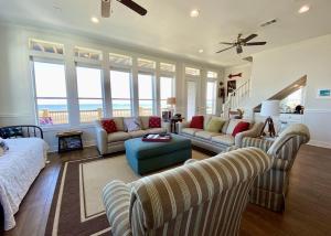 ein Wohnzimmer mit einem Sofa, Stühlen und Meerblick in der Unterkunft Sea Hag home in Stingaree