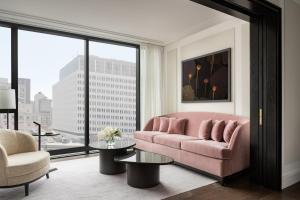a living room with a pink couch and a large window at Four Seasons Hotel Montreal in Montreal