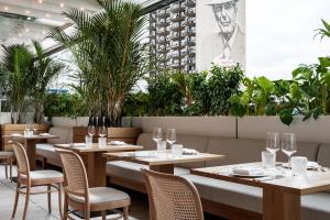 un restaurante con mesas, sillas y plantas en Four Seasons Hotel Montreal en Montreal