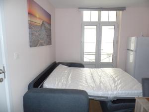 małą sypialnię z łóżkiem i lodówką w obiekcie Beaulieu w mieście Blankenberge