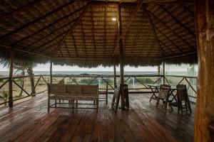 a pavilion with a table and chairs on a wooden floor at Casa de Praia Litoral Piauí in Luis Correia