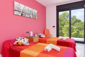 two beds in a room with pink walls at Naranja in Tamariu +10 photos