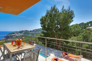 a patio with a table and chairs on a balcony at Naranja in Tamariu