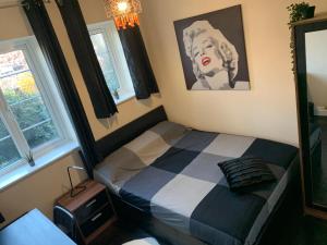a bedroom with a bed and a picture of a woman at Beddington Park Lodge West in Wallington