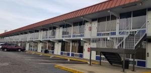 a large building with balconies and a parking lot at Family Inns of America - Mobile in Mobile