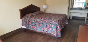 a bedroom with a bed with a colorful comforter at Family Inns of America - Mobile in Mobile