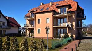a large house with an orange roof at Apartamenty Rybacka 84D in Krynica Morska
