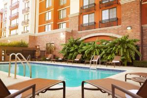 einen Pool mit Tischen und Stühlen in einem Gebäude in der Unterkunft Hyatt Place Fort Worth Stockyard in Fort Worth