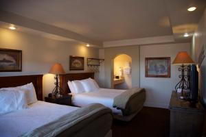 um quarto de hotel com duas camas e uma televisão em The Lodge on Route 66 em Williams