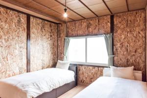two beds in a room with a window at Rustic Modern House in Hakodate in Hakodate +39 photos