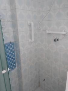 Łazienka z prysznicem wyłożona jest białymi kafelkami. w obiekcie Recanto Santista w mieście Santos