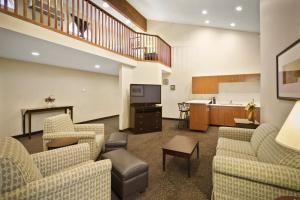 a living room with two couches and a kitchen at AmericInn by Wyndham Hill City Mt Rushmore in Hill City