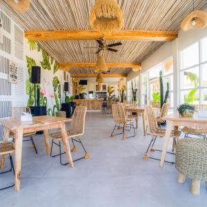 a room with tables and chairs and a ceiling at Luminor Hotel Banyuwangi By WH in Banyuwangi