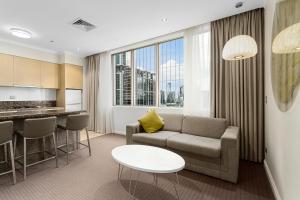 a living room filled with furniture and a large window at Clarion Suites Gateway in Melbourne