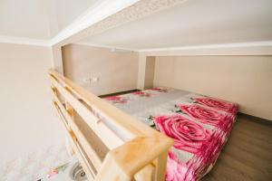 a small room with a bunk bed with pink roses at Dekabrist Apartment Bogomyagkogo 66 in Chita