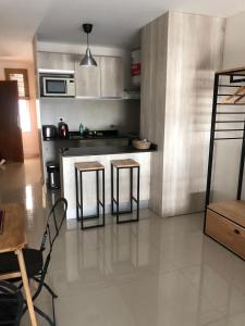 a kitchen with two bar stools and a counter at 9 de Julio 2200 in Rosario +1 photo