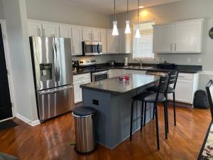 a kitchen with white cabinets and a stainless steel refrigerator at The La Grange House in Cleveland +11 photos