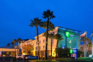 a hotel with palm trees in front of a building at Holiday Inn Express Hotel & Suites Vacaville by IHG in Vacaville