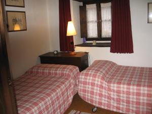 een kamer met 2 bedden, een tafel en een raam bij Casa Turpesa in Peñalba de Santiago