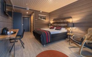 una camera con letto, scrivania e sedia di Wilderness Hotel Inari & Igloos a Inari