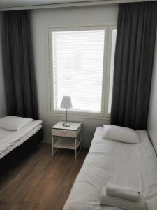 um quarto com 2 camas e uma janela em Siljonportti Apartments em Rovaniemi