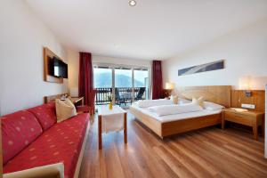 a hotel room with a bed and a couch at Feldhof Schenna in Schenna +49 photos
