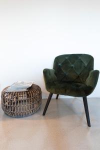 a green chair and a basket next to a table at Hof Olmenstein in Goes