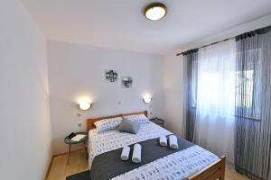 a bedroom with a bed and a large window at Apartment Martina in Krk