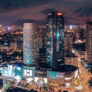 a city lit up at night with tall buildings at Tangla Hotel Tianjin in Tianjin