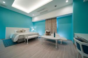 um quarto com paredes azuis, uma cama e uma mesa em HOTEL LASCALA em Wakayama