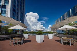 a patio with tables and chairs with umbrellas at Crimson Hotel Filinvest City, Manila in Manila