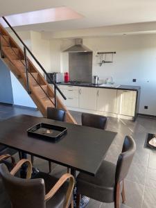 eine Küche mit einem Tisch und Stühlen sowie eine Küche mit einer Treppe in der Unterkunft Apartment Meylhof in Kontich
