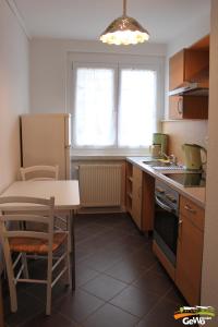 a kitchen with a table and a small table and a kitchen with a refrigerator at Ferienwohnung August 30 in Gelenau