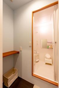 a bathroom with a toilet and a mirror at plat hostel keikyu asakusa karin in Tokyo