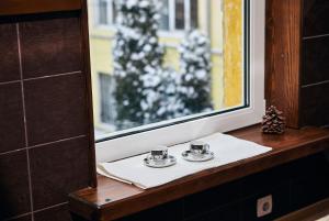 two tea cups on a table next to a window at Mirrors in Vinnytsya