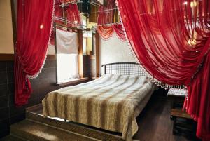 a bedroom with red curtains and a bed in a room at Mirrors in Vinnytsya
