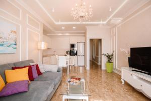 ein Wohnzimmer mit einem grauen Sofa und einer Küche in der Unterkunft Luxury for business & pleasure Royal 1 in Kiew