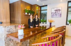 two women standing behind a large table in a room at HANA Stay in Hanoi