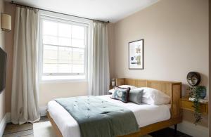 倫敦的住宿－Luxurious 1 Bedroom Apartment - minutes from Angel Tube St.，一间卧室设有一张床和一个大窗户