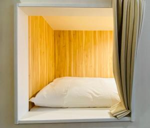 Bett in einem Zimmer mit Fenster in der Unterkunft bnb+ Shinsaibashi in Osaka