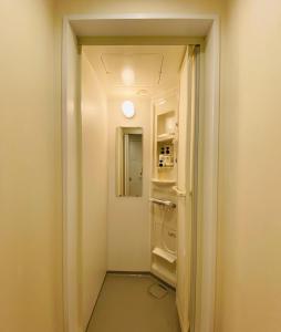 einen Flur mit einer Tür, die in ein Zimmer führt in der Unterkunft bnb+ Shinsaibashi in Osaka