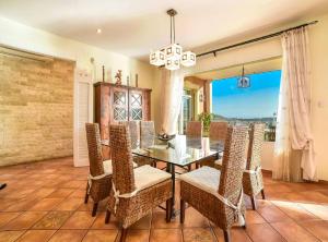 a dining room with a glass table and chairs at Villa Eden - Plusholidays in Calpe