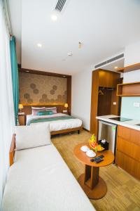 a bedroom with a bed and a kitchen with a table at HANA Stay in Hanoi