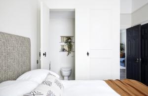 biała sypialnia z łóżkiem i toaletą w obiekcie Modern 1 Bedroom Apartment - minutes from Angel Tube St. w Londynie