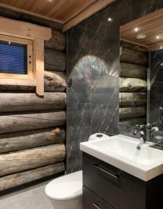 a bathroom with a white sink and wooden walls at Wilderness Hotel Muotka & Igloos in Saariselka