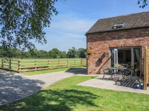 a brick building with a table in front of a fence at Cherry Tree Barn in Shrewsbury