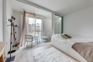 Dormitorio blanco con cama y mesa en Le Rivage, en Arzon