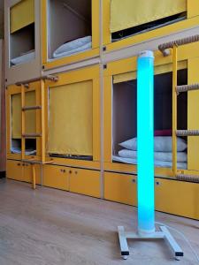 モスクワにあるCapsule Hostel Yesの黄色の二段ベッド(青いポール付)が備わる客室です。