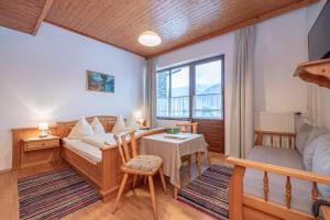 een kamer met een bed, een tafel en een bank bij Landhof zum Waidegger Wirt in Waidegg