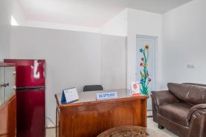 ein Wohnzimmer mit einem Sofa und einem Kühlschrank in der Unterkunft OYO Life 2391 Baladewa Residence Syariah in Karawang